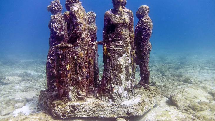 Human sculptures standing underwater