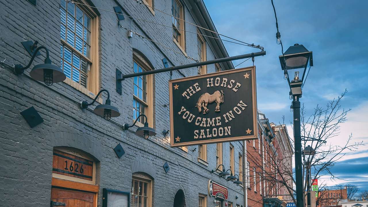 A sign that says "The Horse You Came In On Saloon" hanging from an old building