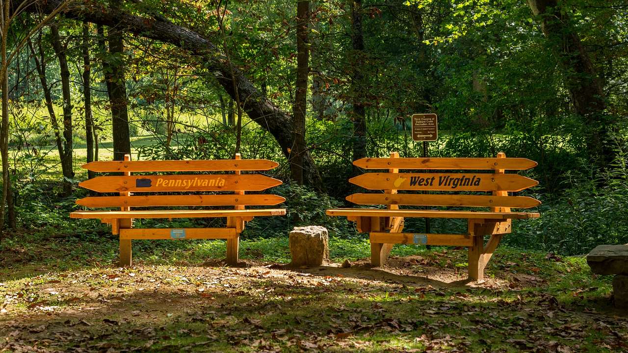 Two wooden benches with "Pennsylvania" and "West Virginia" painted on them