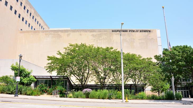 A square-shaped structure with a "Milwaukee Public Museum" sign next to trees