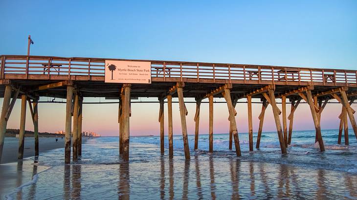 Looking up at a wooden pier with a blue and pink sky in the background