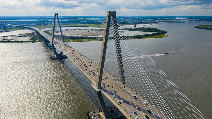 Aerial view of vehicles crossing a huge river on a cable-stayed bridge