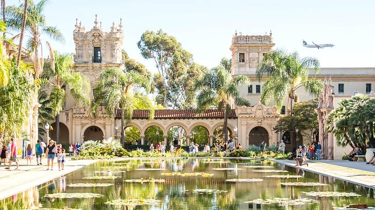 A castle-like structure with a pond and palm trees in front of it