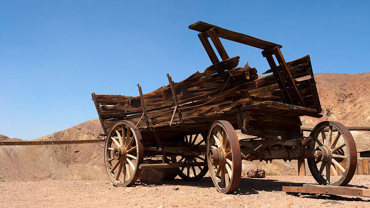 An old wooden wagon left in the desert under a clear blue sky