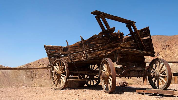 An old wooden wagon left in the desert under a clear blue sky