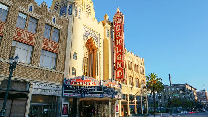 A facade of an intricately-designed building with a sign saying "Fox Oakland"