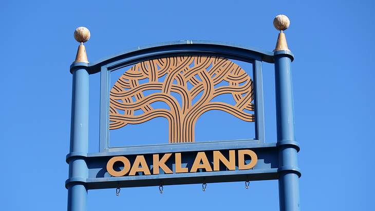 A sign saying "Oakland" with an oak tree design on top of it