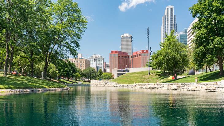 A body of water surrounded by trees with buildings in the distance