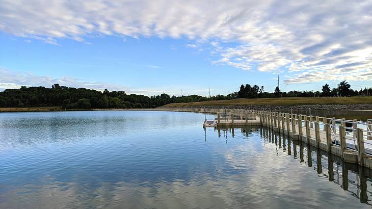 A dock surrounded by a body of water with trees in the distance