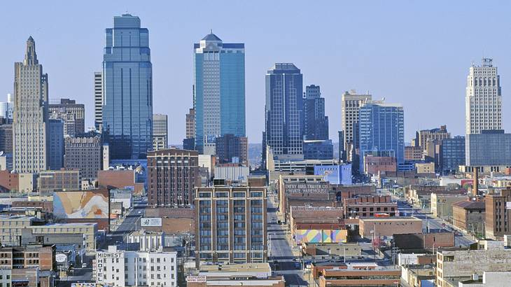 A view of a city with tall buildings and roads under a blue sky