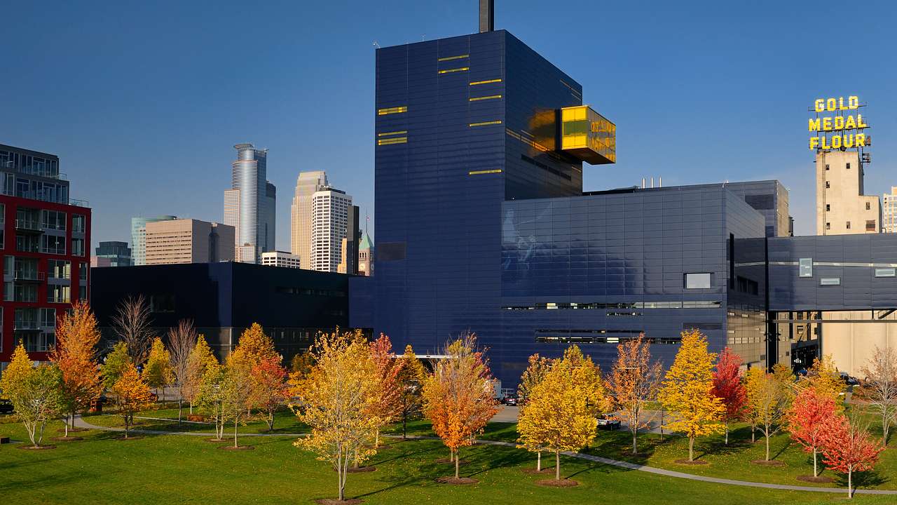 A black post-modern-style building with trees in fall
