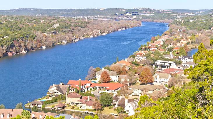 A view over a river and a town with houses and trees