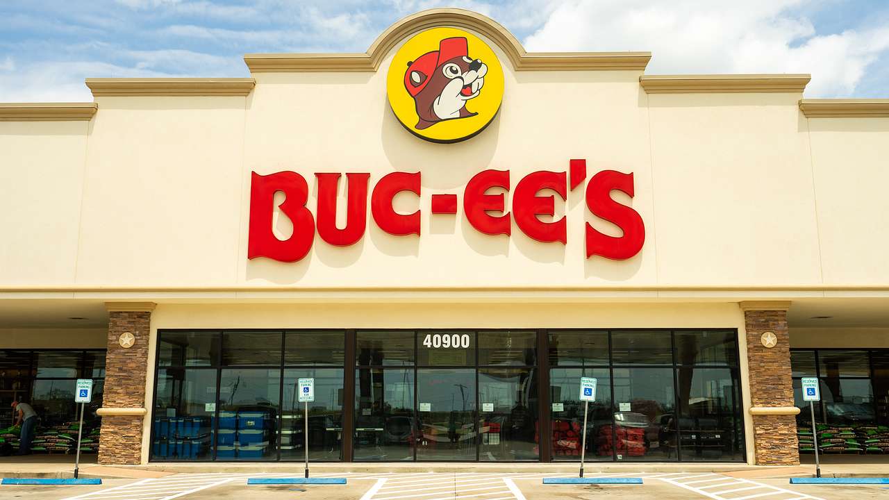 A large yellow building with a red sign on it, "Buc-ee's" on a nice day
