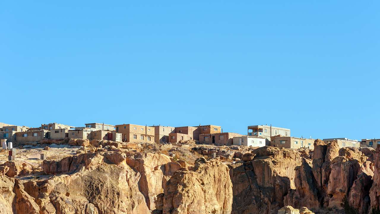 A village with small houses on a rugged cliffs under a clear blue sky