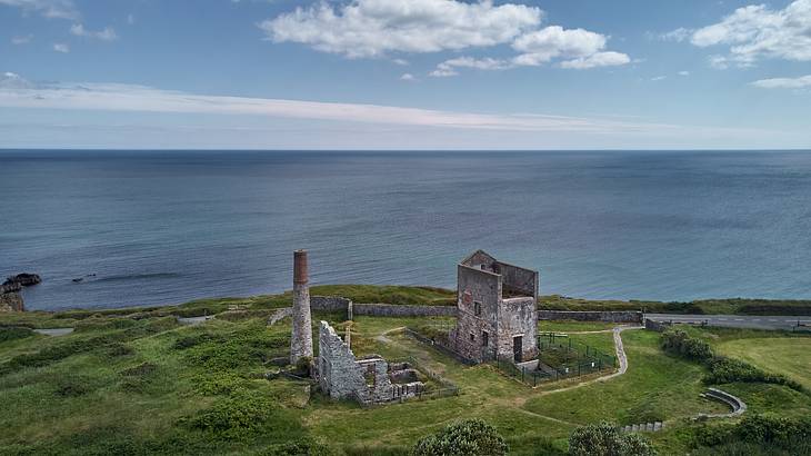 Aerial shot of abandoned mine ruins, overlooking an ocean