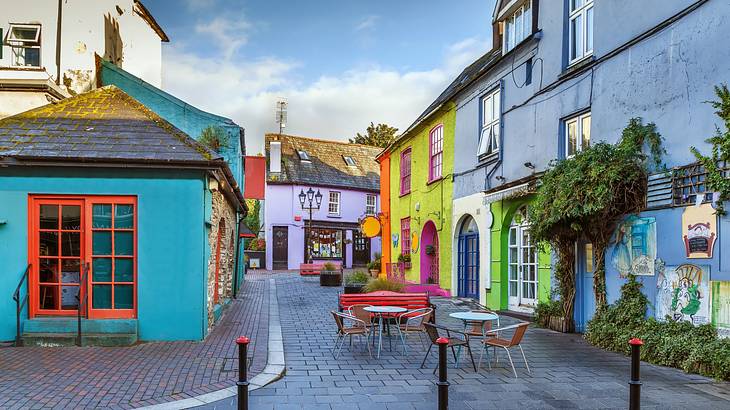 Brightly-coloured houses lining a street with a brick road