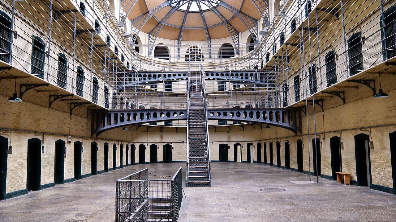 The interior of a multi-level prison with stairs and jail cells