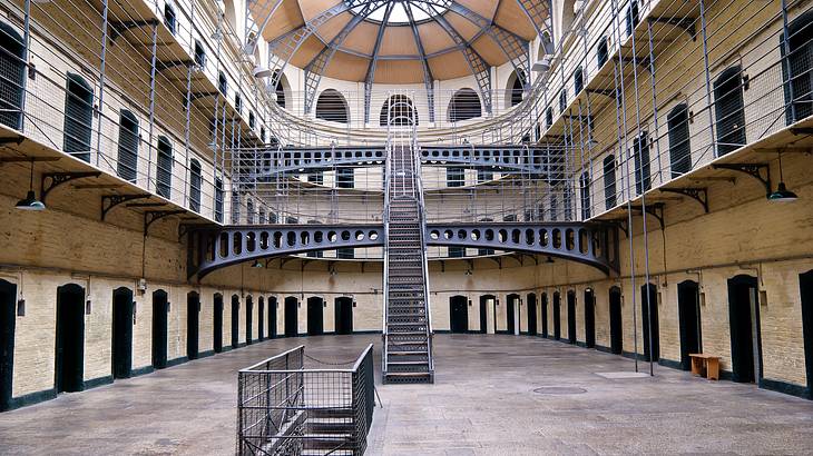 The interior of a multi-level prison with stairs and jail cells