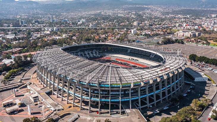 Aerial of a stadium with short city buildings and greenery around