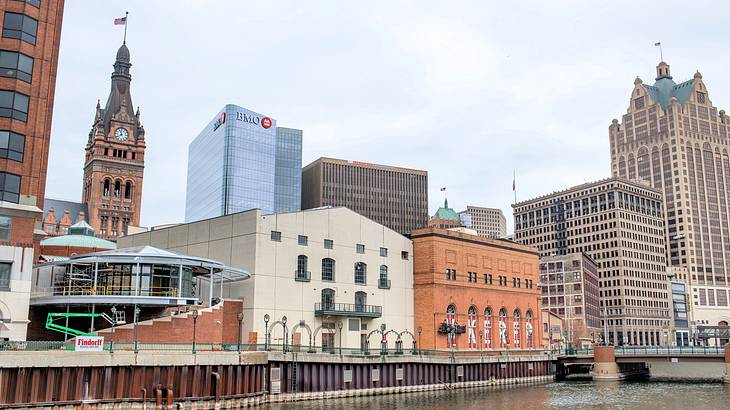 Buildings near a river under a cloudy sky