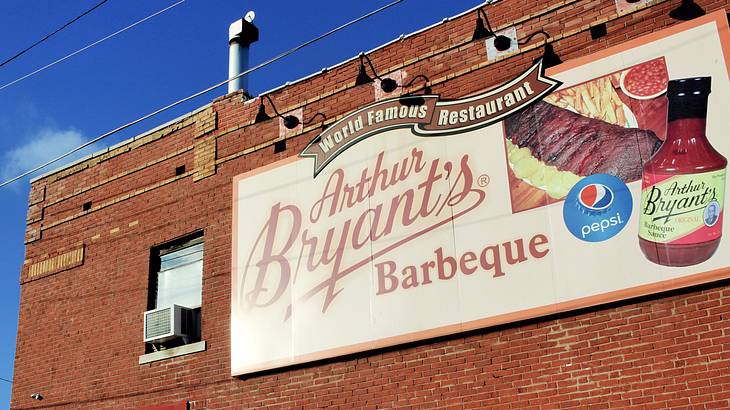 A billboard on a bricked building saying "Arthur Bryant's Barbeque"