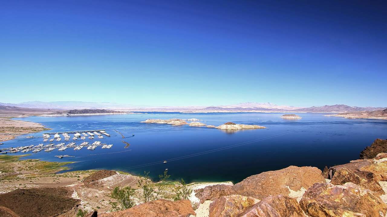 A lake with mountains surrounding and small islands in the water