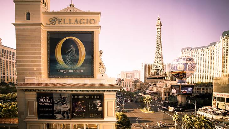 A hotel with Cirque du Soleil sign and Eiffel Tower and balloon replica behind it