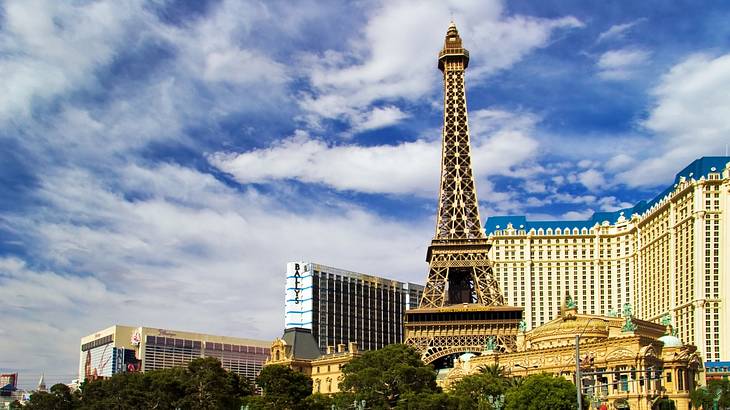 A replica of the Eiffel Tower with buildings around it and water in front