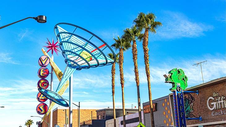 A sculpture of a martini glass with palm trees next to it