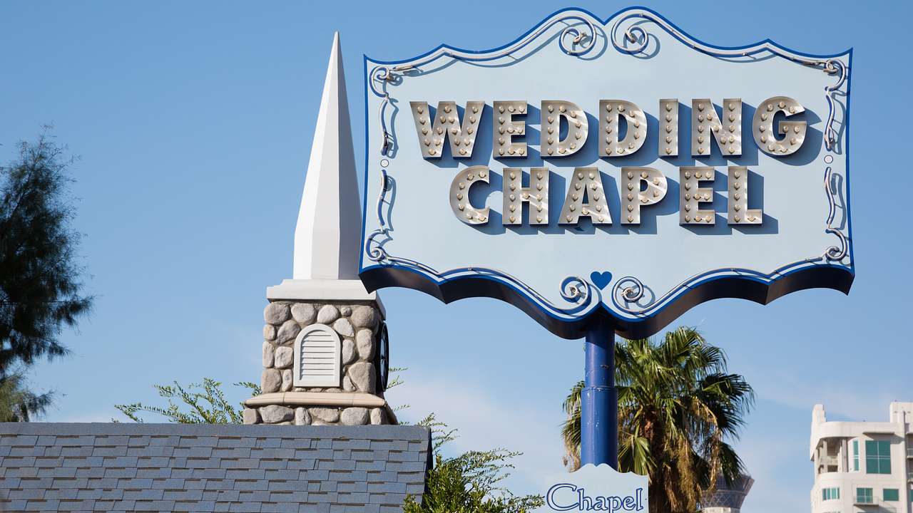 A church-style spire and a large light blue sign that says Wedding Chapel