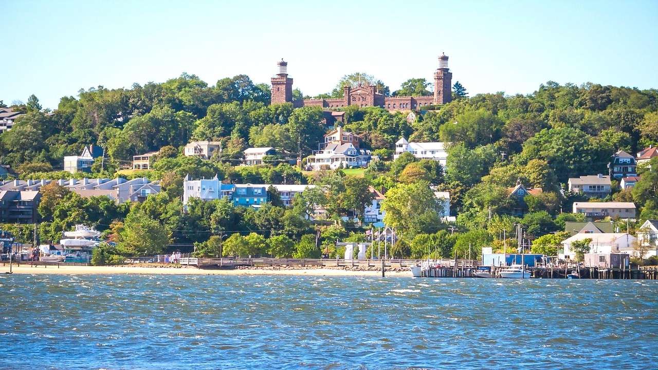 A bay of water with trees, buildings, and a castle-like structure on the shore