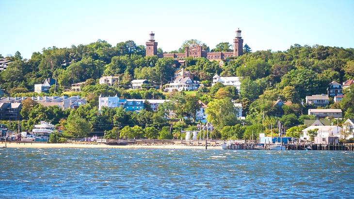A bay of water with trees, buildings, and a castle-like structure on the shore