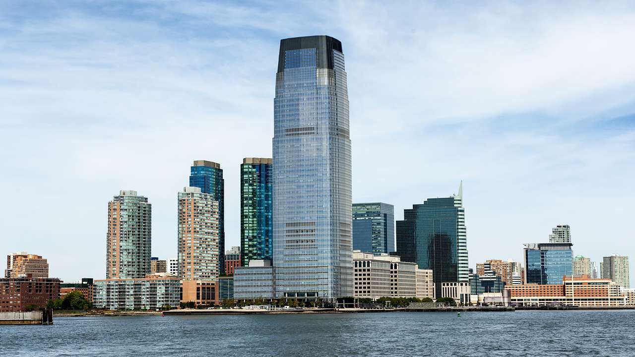 A skyscraper among buildings on the coast of a city along a river