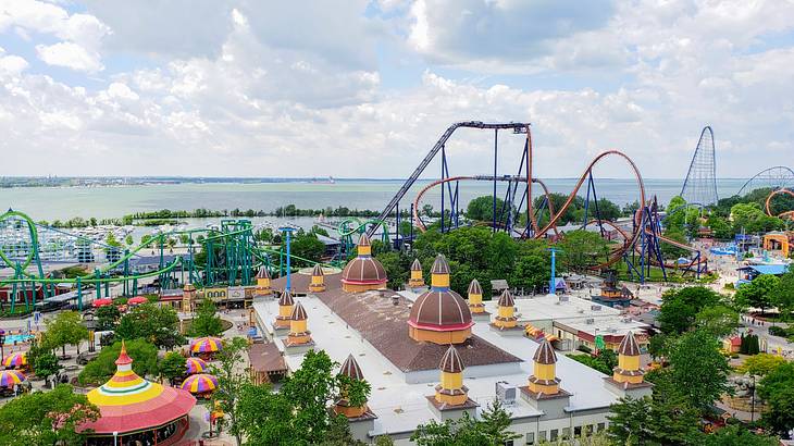 Aerial view of various rides and attractions in an amusement park overlooking a lake
