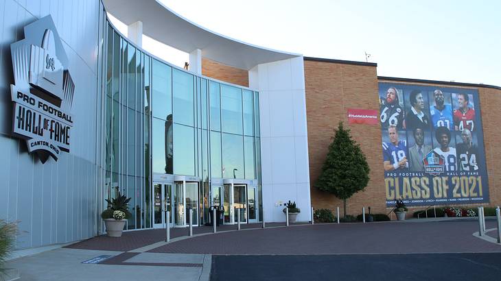 A building with floor-to-ceiling glass windows and a huge banner of football players