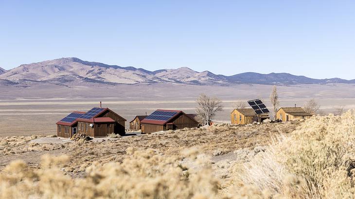 Abandoned houses in the desert with mountains in the background