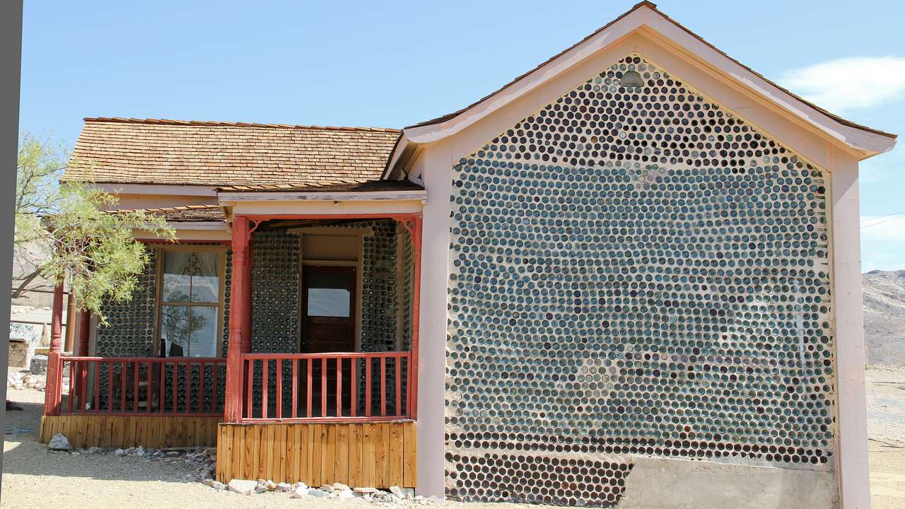A vernacular house made out of bottles on a sunny day