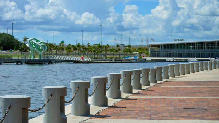 A walkway alongside the banks of a body of water on a sunny day