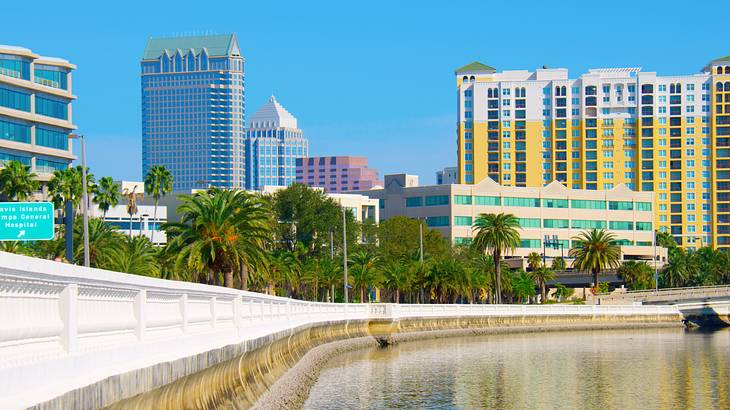 A body of water near a long walkway and many buildings