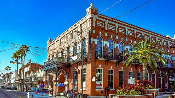 A brick building with many windows next to a street