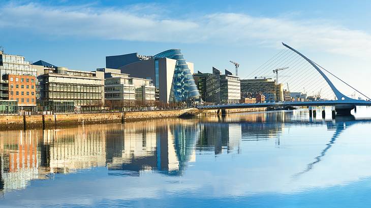 Buildings and other modern structures with their reflection on a nearby body of water