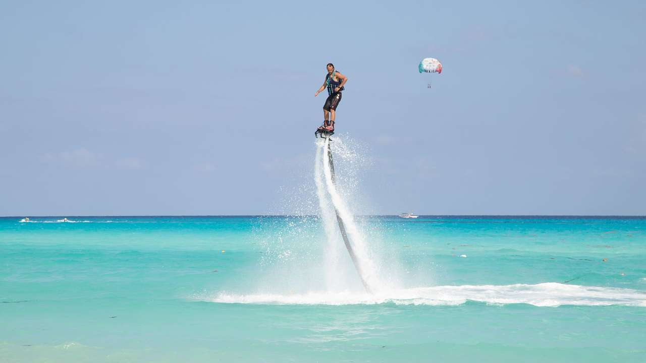 A man posing on a flyboard against the backdrop of a clear blue sky at the beach