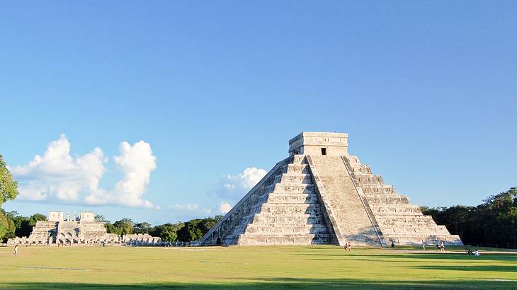 A pyramid-like temple surrounded by grass and blue sky