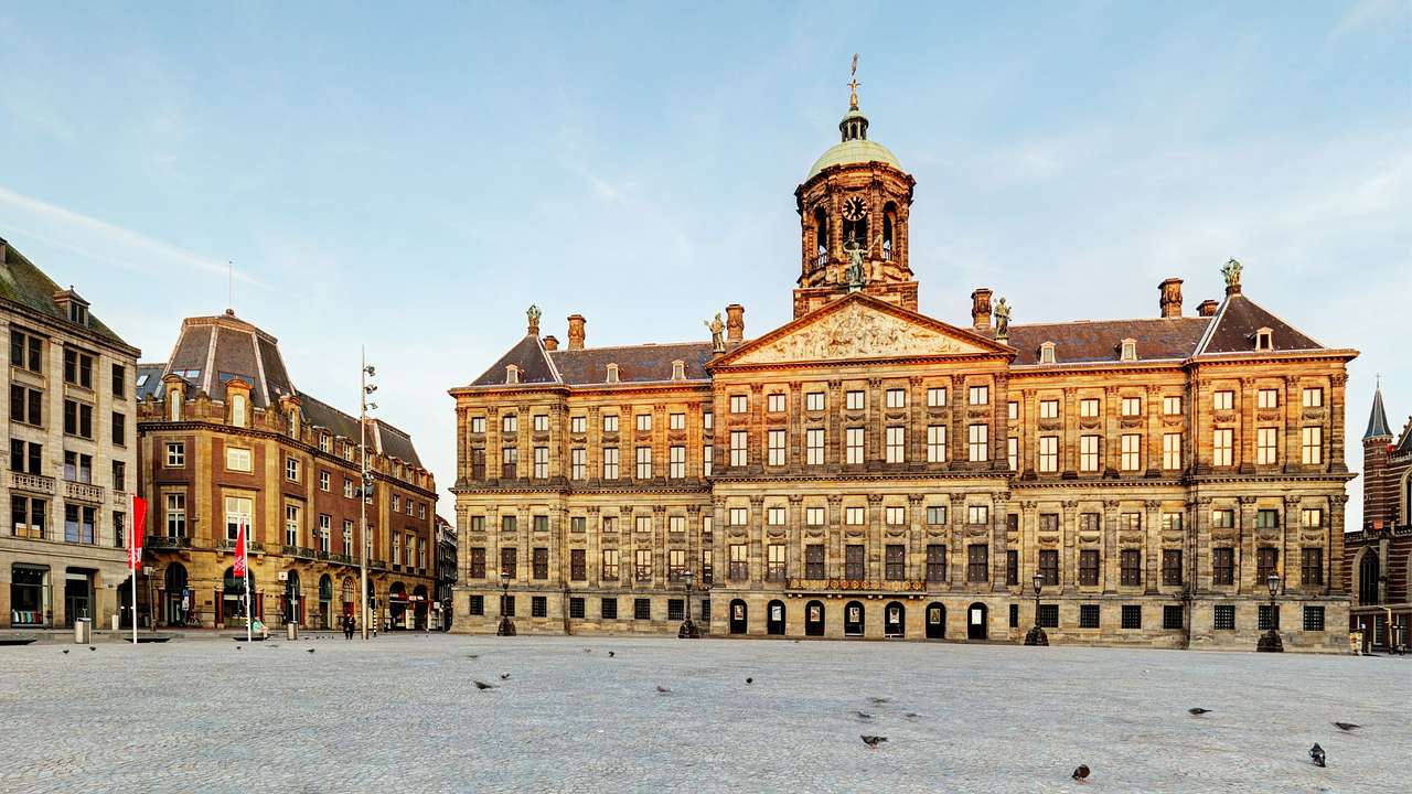 A large palace building with many windows next to a square