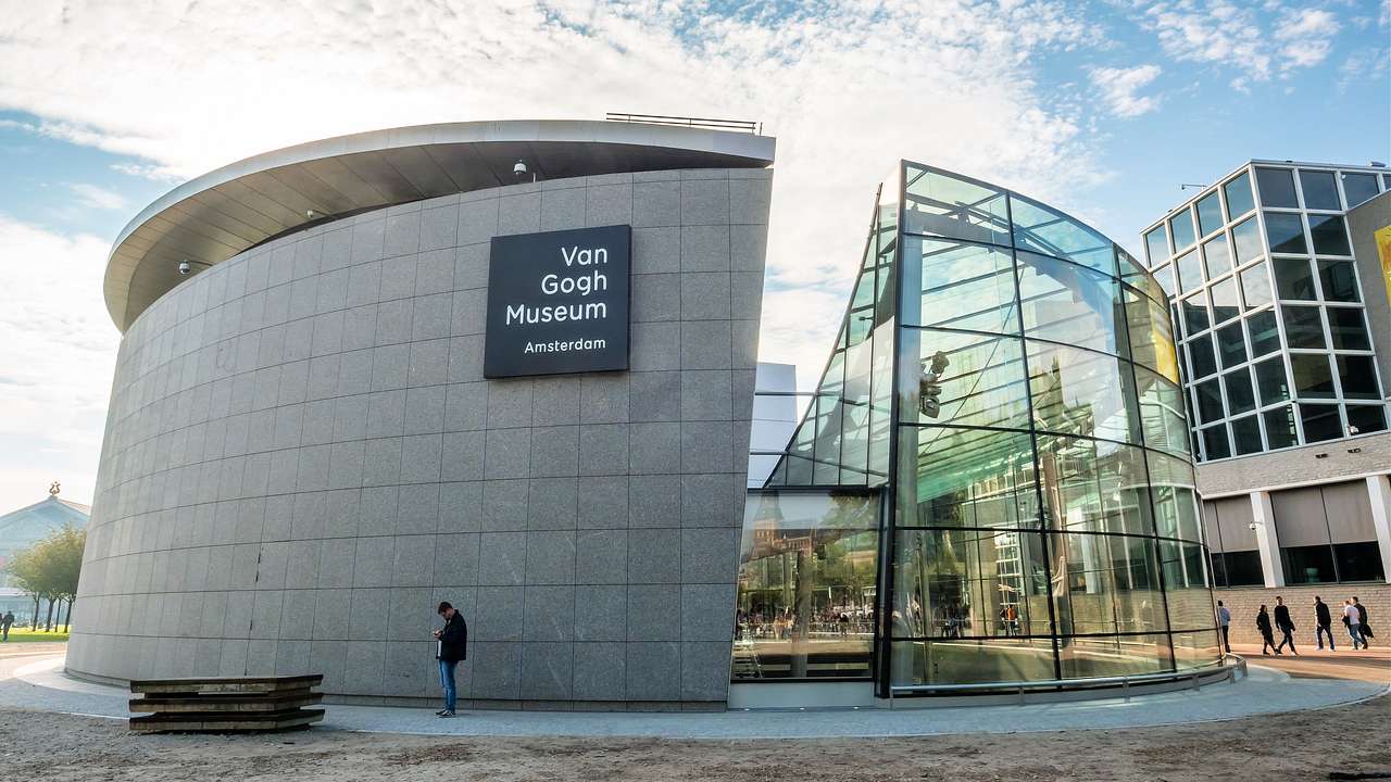 A modern spherical-shaped building with glass panels and a "Van Gogh Museum" sign