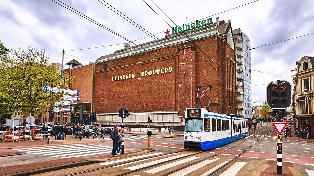 A train near a bricked building with a sign saying "Heineken"