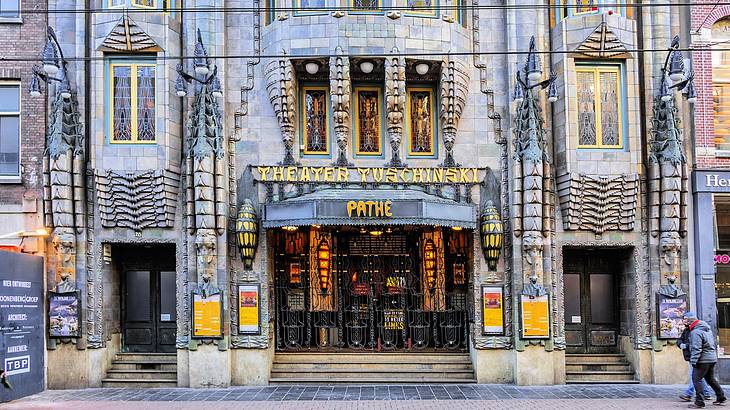 An intricately-design building facade that says "Theater Tuschinski" and "Pathe"