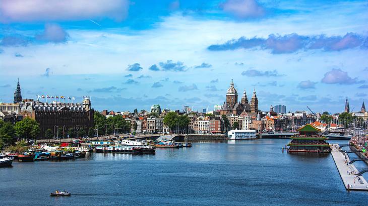 Buildings and a church near a body of water under a blue sky with clouds