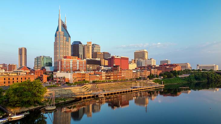 A body of water, multiple-sized buildings, and blue sky