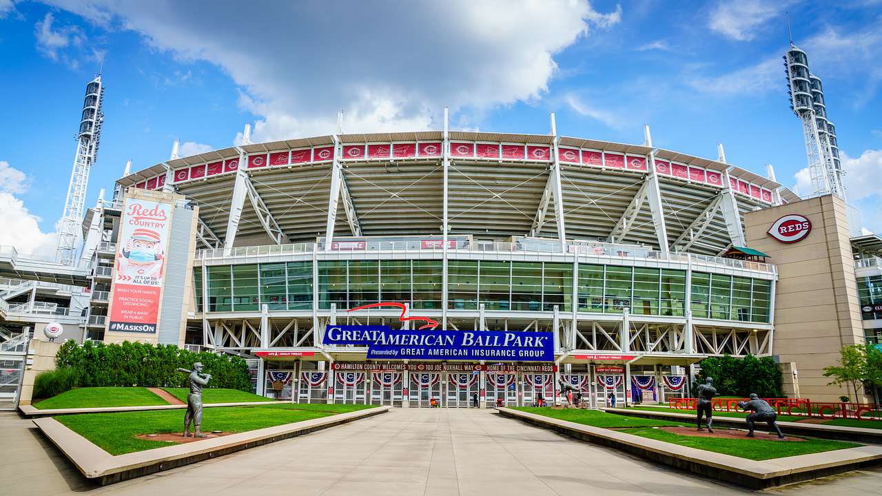 The outside of a baseball stadium with a walkway and grass on either side